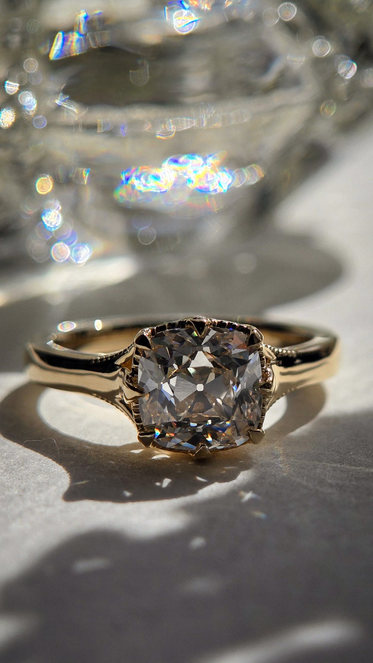 Front view of The Margaux with an Old Mine cushion-cut lab-grown diamond in a yellow-gold prong setting.Milgrain around its yellow-gold setting basket and shoulders.