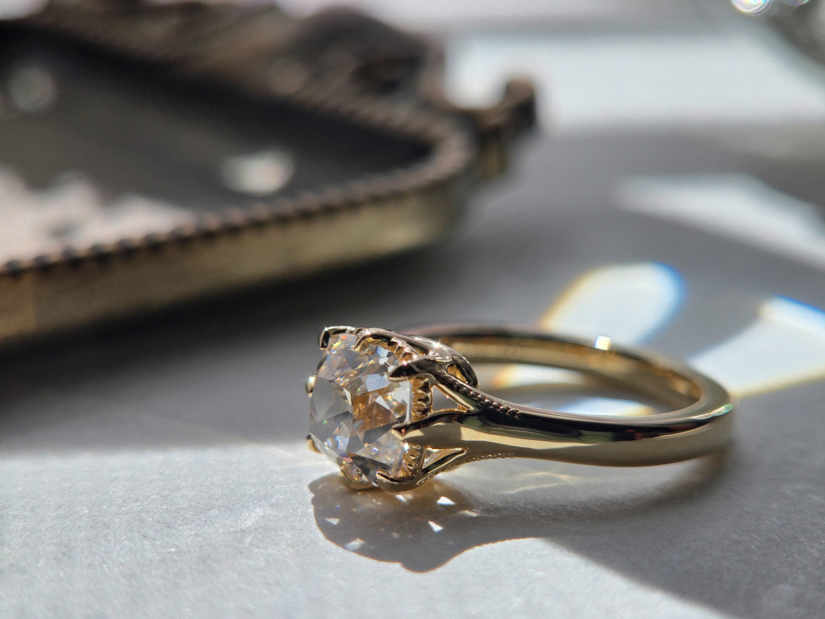 Side profile of The Margaux showing its open prong setting and polished yellow-gold band. Old mine cushion lab grown diamond center stone 