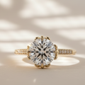 Front view of The Emerlyn with a round brilliant-cut lab-grown center diamond and pavé diamonds along a yellow-gold band.
